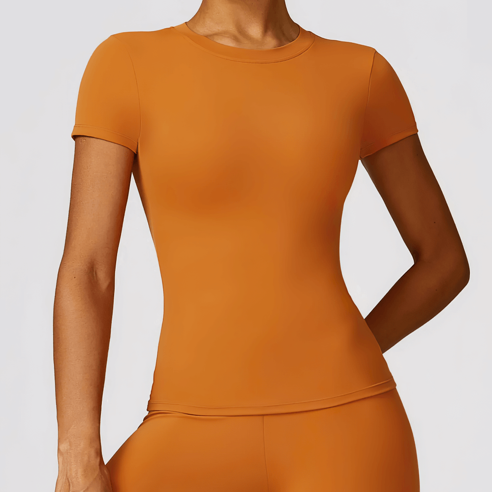 Women’s seamless orange short-sleeve yoga T-shirt, breathable nylon-spandex blend, perfect for fitness and active wear.
